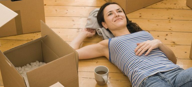a woman laying on the floor surrounded by moving boxes