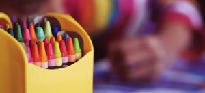 Kid drawing with crayons