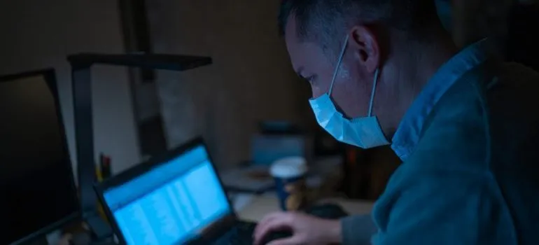 Man with a mask working from home in NYC