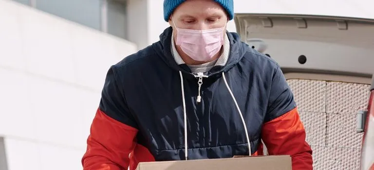 -a man with a mask holding a box