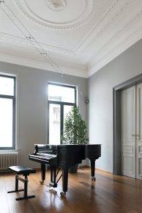 A piano in the middle of an empty room
