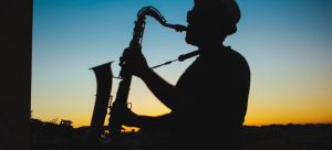 Silhouette of a man playing saxophone during sunset