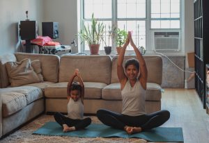 Mom and daughter doing yoga as a way on how to have fun with your kids in the house