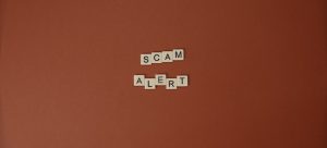 the word scam alert as letters from scrabble to represent a hired fraudulent mover