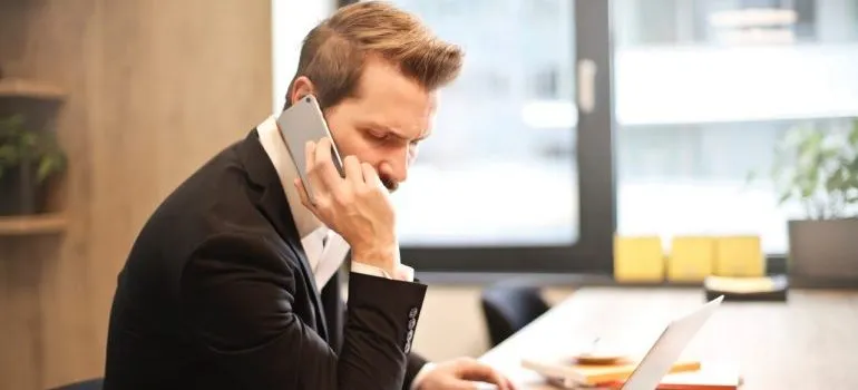 Man having a phone call in front of the laptop