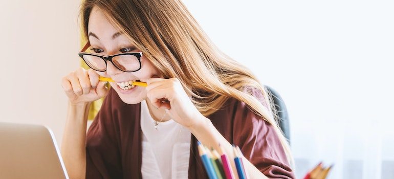 woman bitting a pencil, trying to avoid common moving mistakes