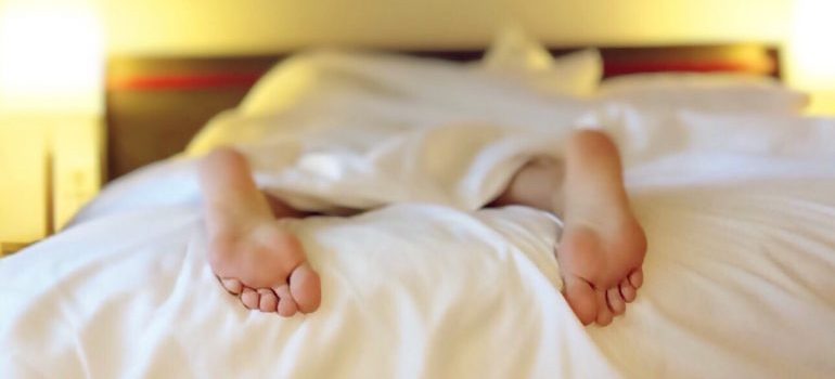 A woman's feet sticking out from under the covers.