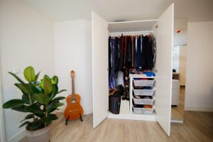 An open closet and a guitar next to it is where you start to declutter your closet for spring