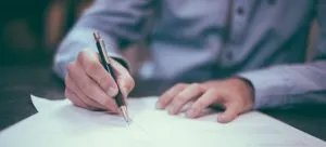 man signing a document