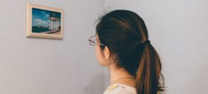 Picture of a woman looking at a painting on the wall