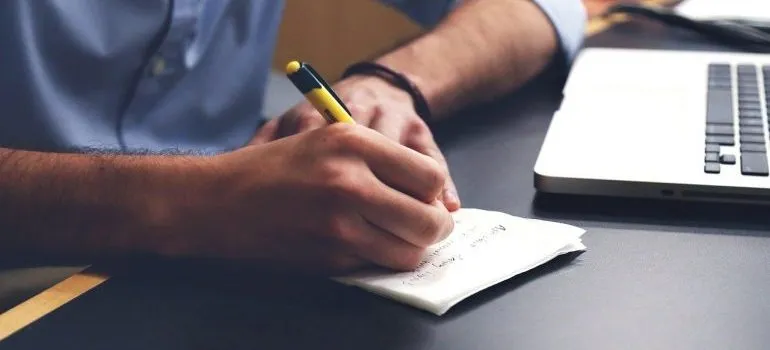 a man writting - avoid additional moving expenses