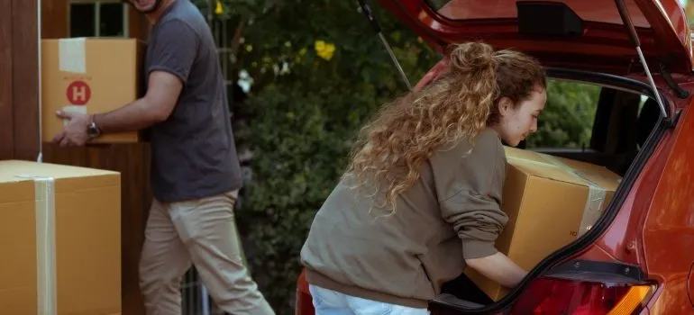 the couple puts the boxes in the car