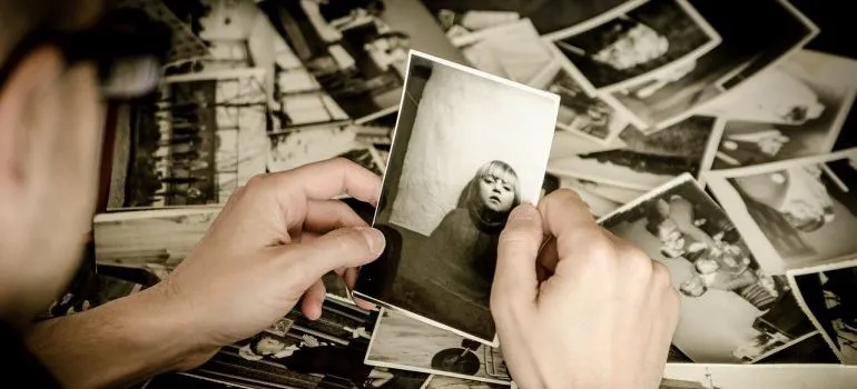 a man holding a photo - pack photographs when moving to Manhattan