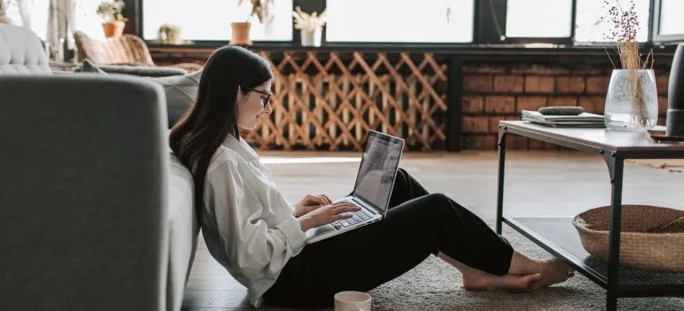 Woman using a laptop searching for movers to move a piano in bad weather