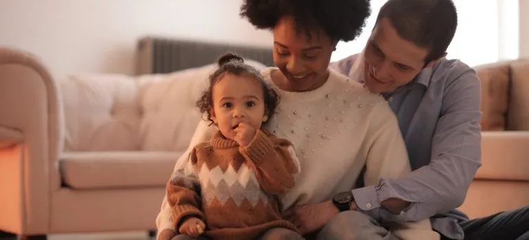parents sitting on the floor with their toddler after preparing a long-distance move with toddlers