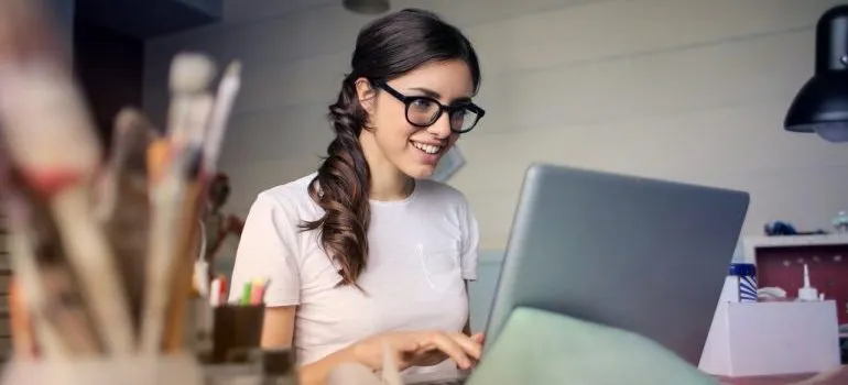 A woman using her laptop to make a plan how to pack her apartment in a week