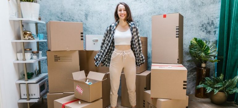 Smiling woman standing in front of moving boxes