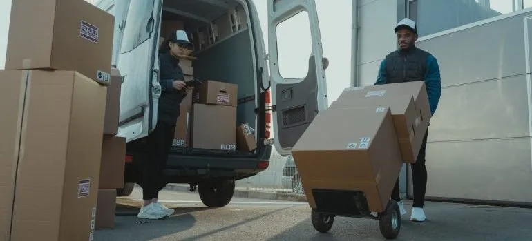 Man pushing a moving dolly with boxes on it