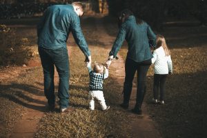 a family of four with a toddler and a small child walking through the park