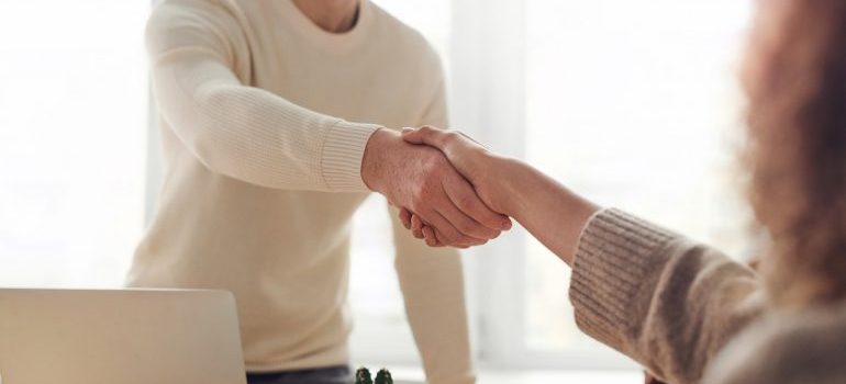 Person shaking hands after hiring movers to move sensitive items in bad weather